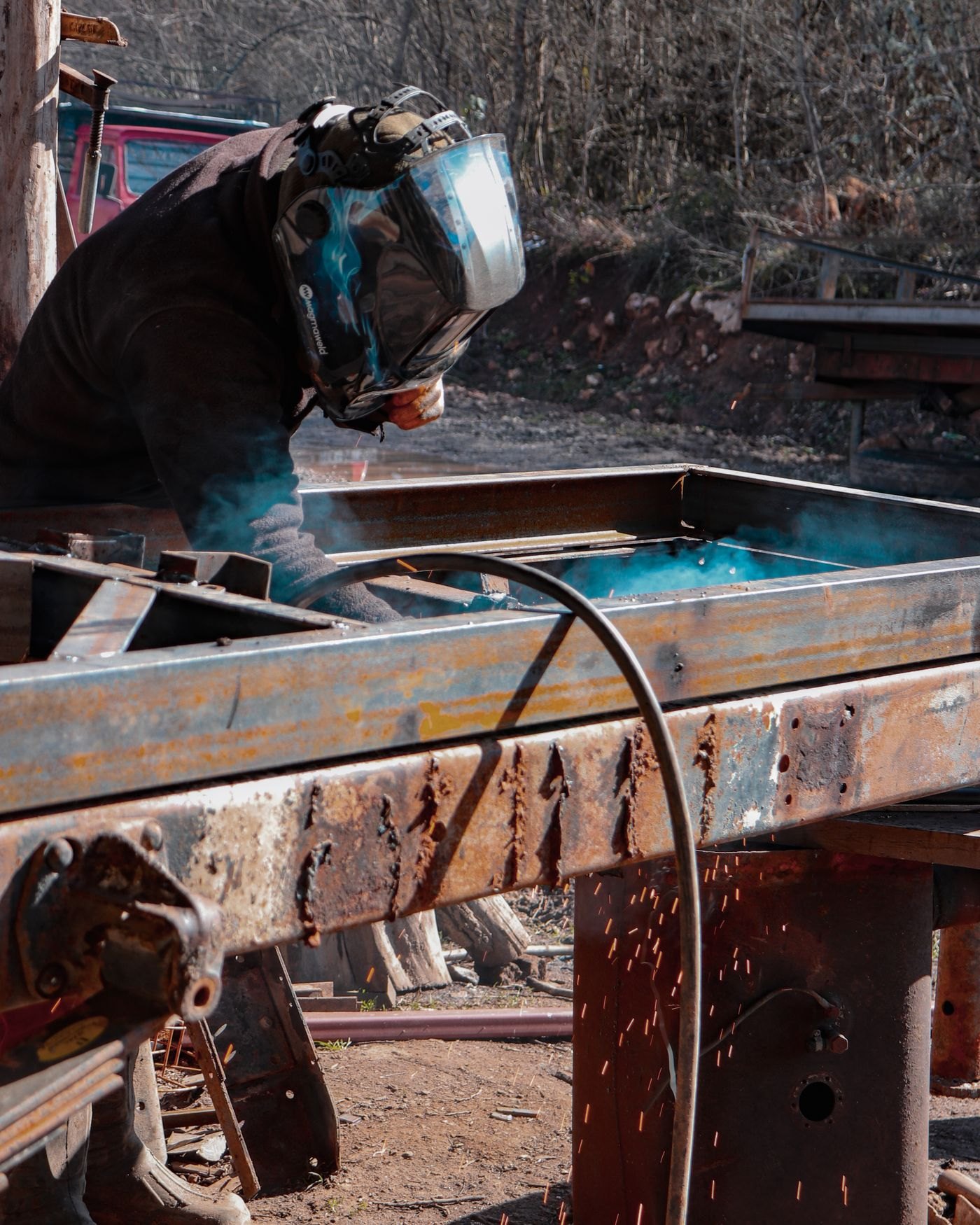 Welder working on a steel frame outdoors